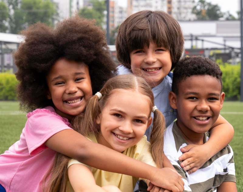 Four happy children smiling outside
